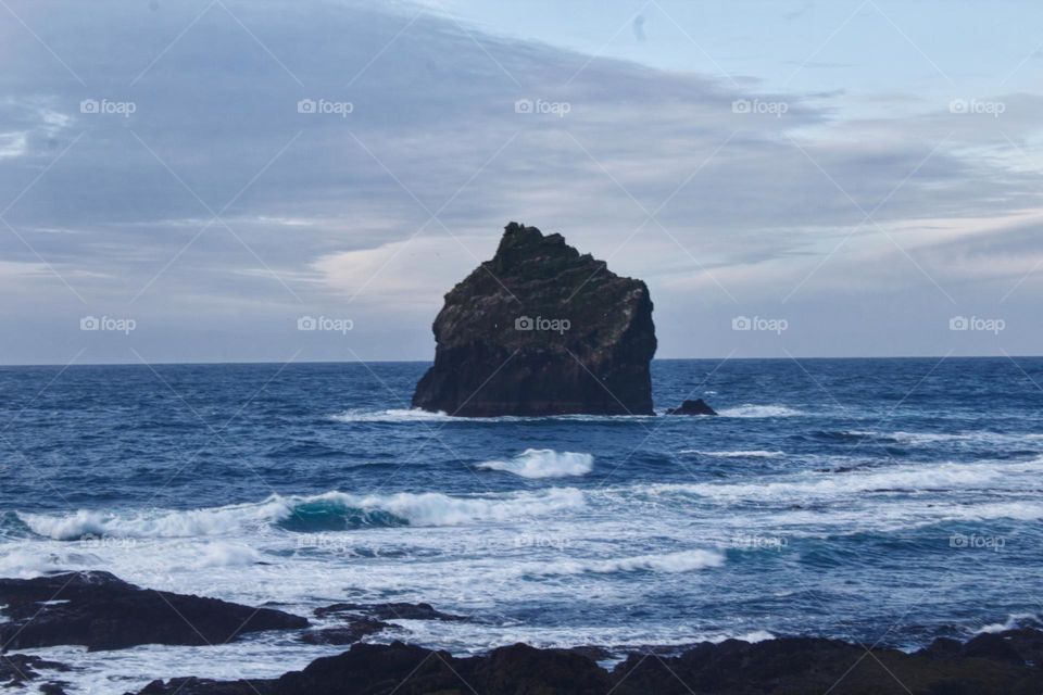 Solitary rock being washed by the ocean in Iceland.