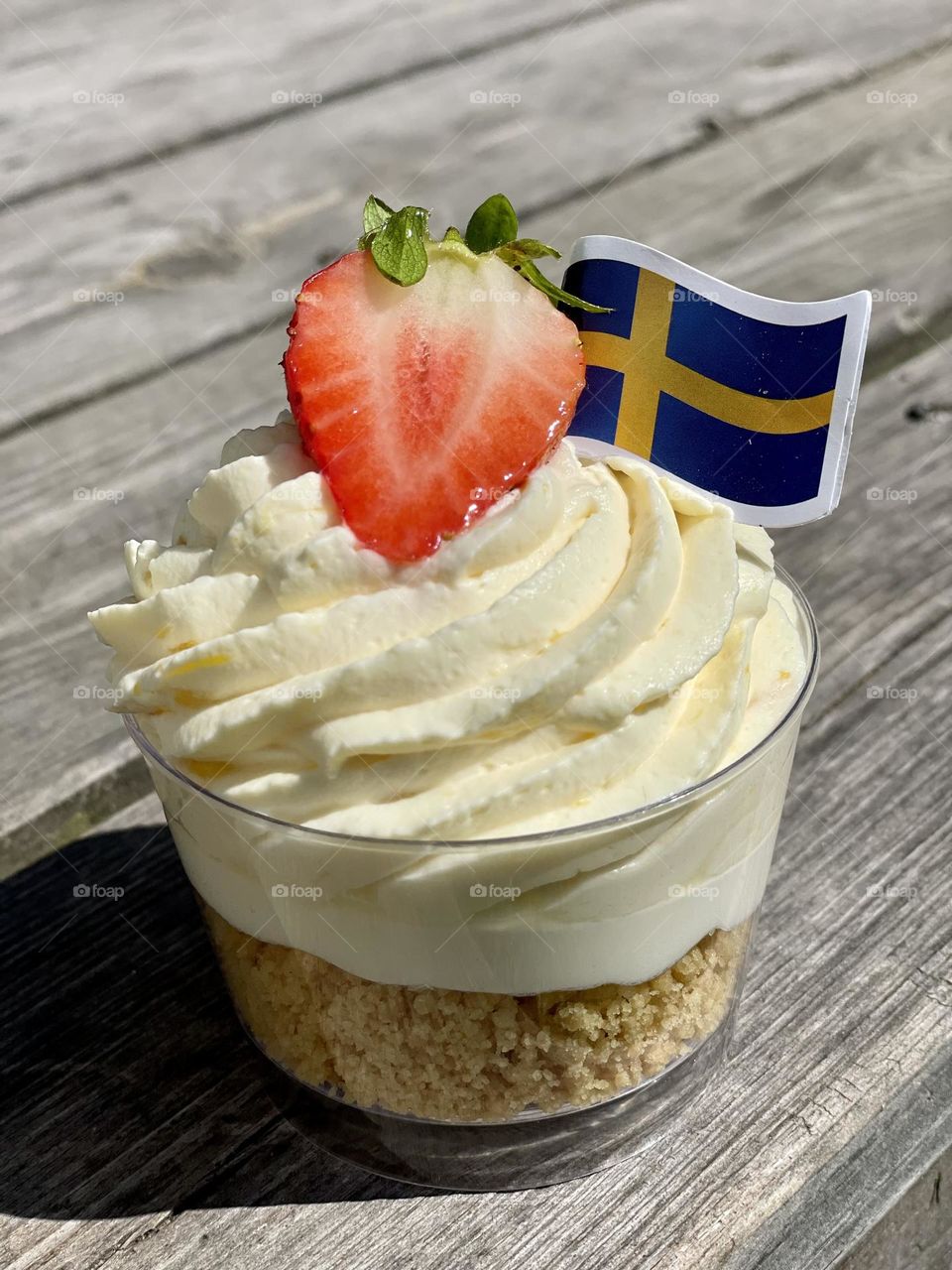 Celebrating the National Day in Sweden with delicious pastry decorated with strawberry and the Swedish flag on the top 