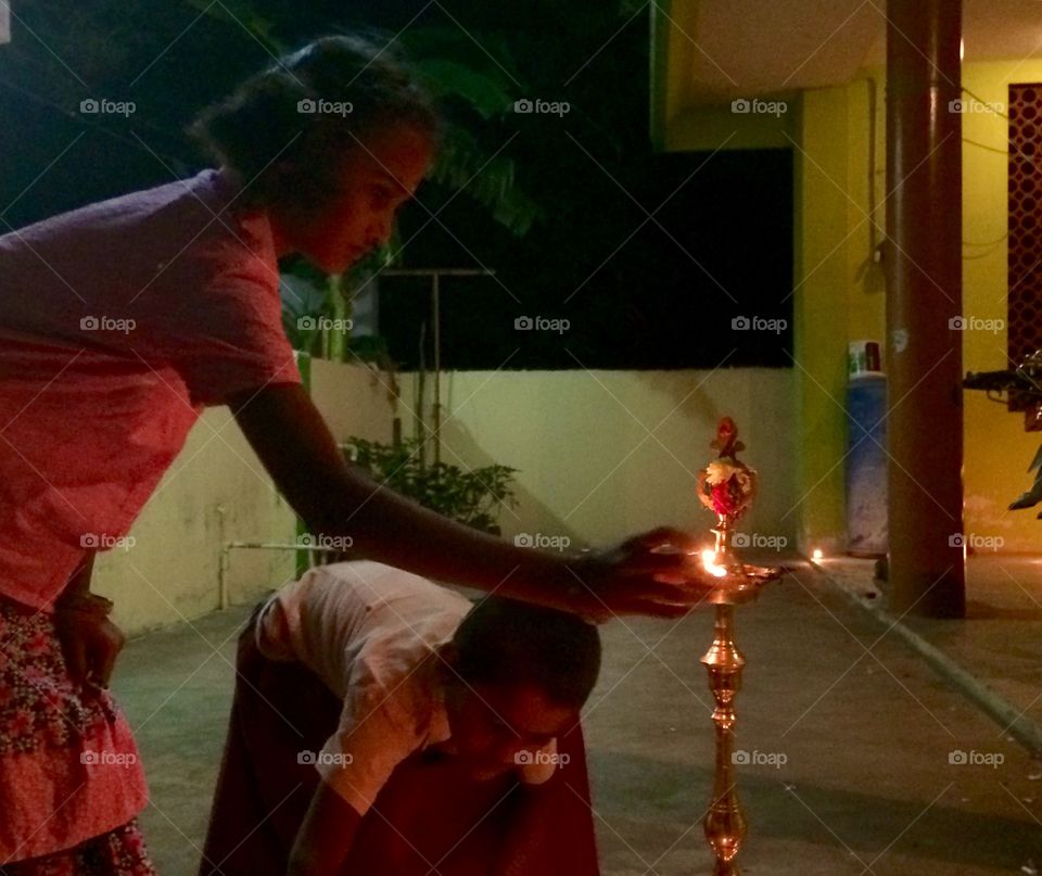 Indian girls lighting the oil lamp