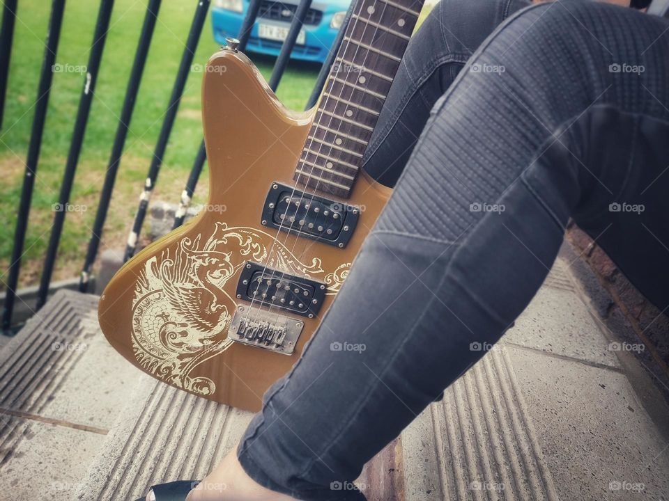Female sitting with Electric Guitar