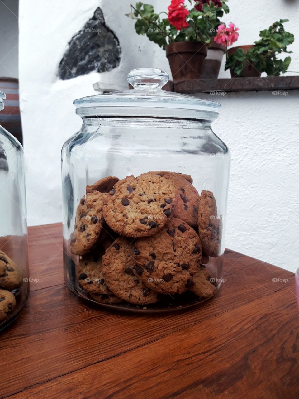 cookie jar in a wood table with a white wall behind
