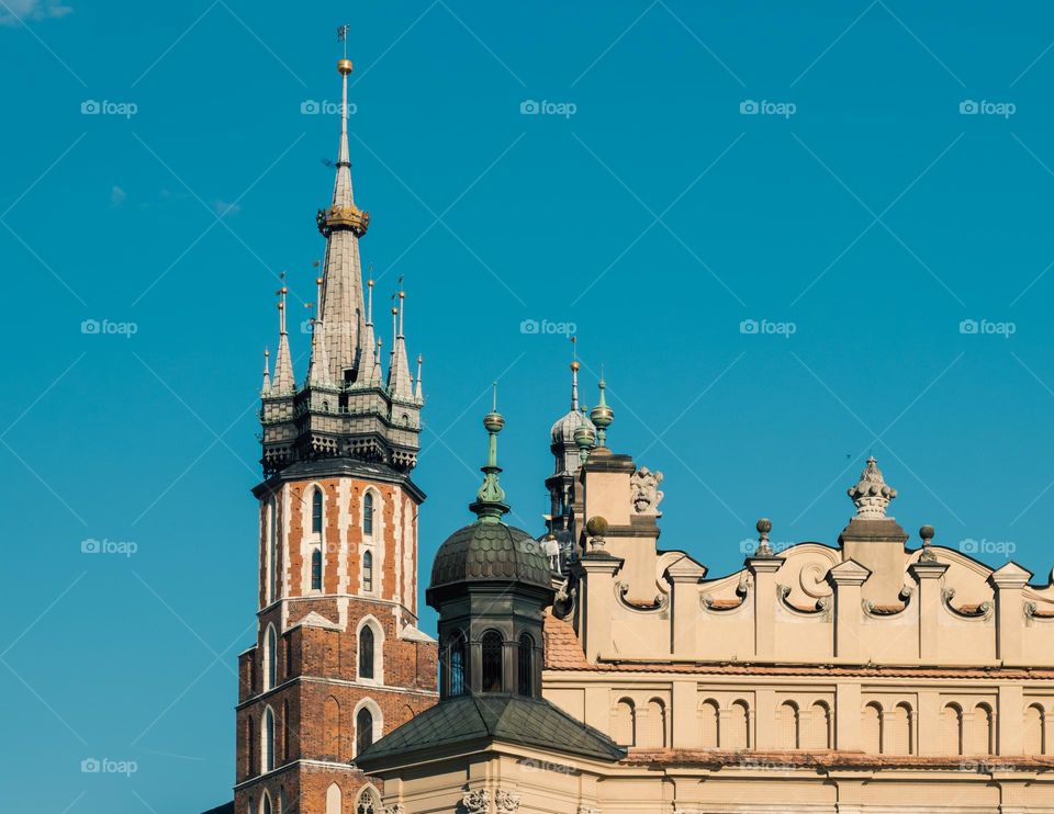 the tower of the historic St. Mary's Church in the company of the Cloth Hall on the market square