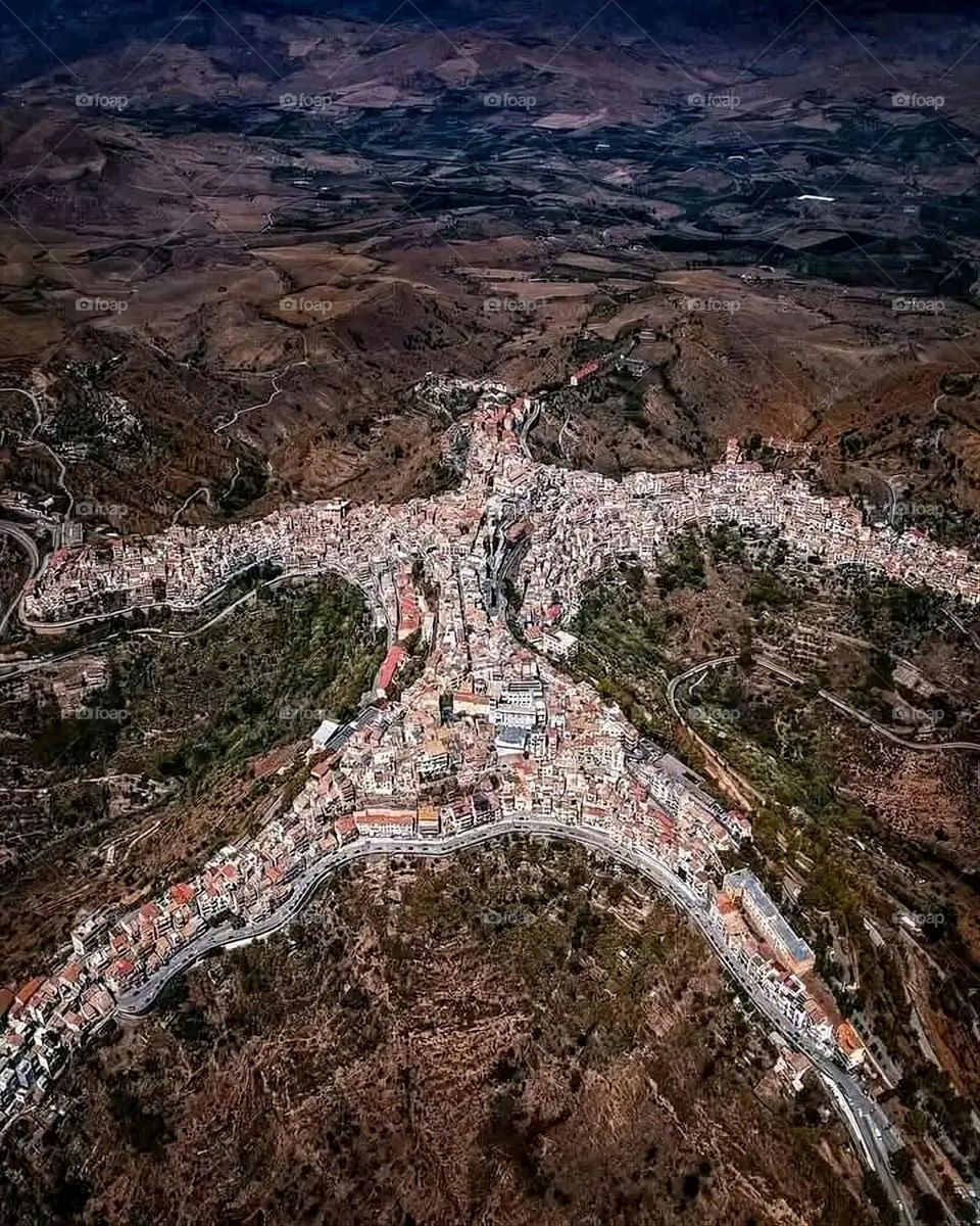 The image embodies a natural natural plate of the mountains of nature, where green agricultural stands are graded on the slopes as if they were lines of a poem, which fog harmoniously wrapped, and clouds hugged them in the mountain knife and the whis