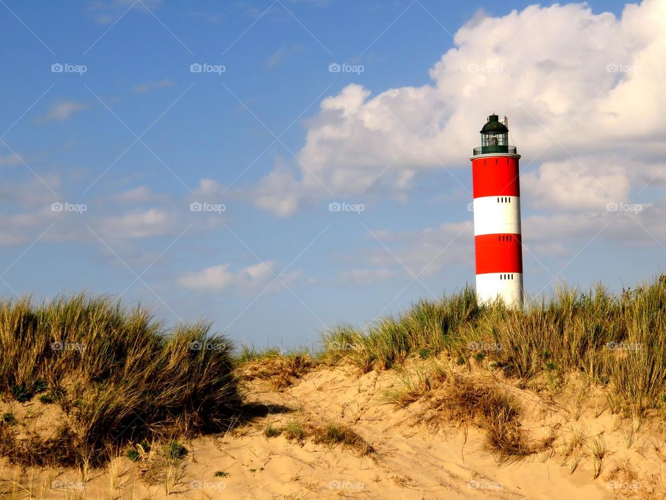 colourful lighthouse on a sand dune 