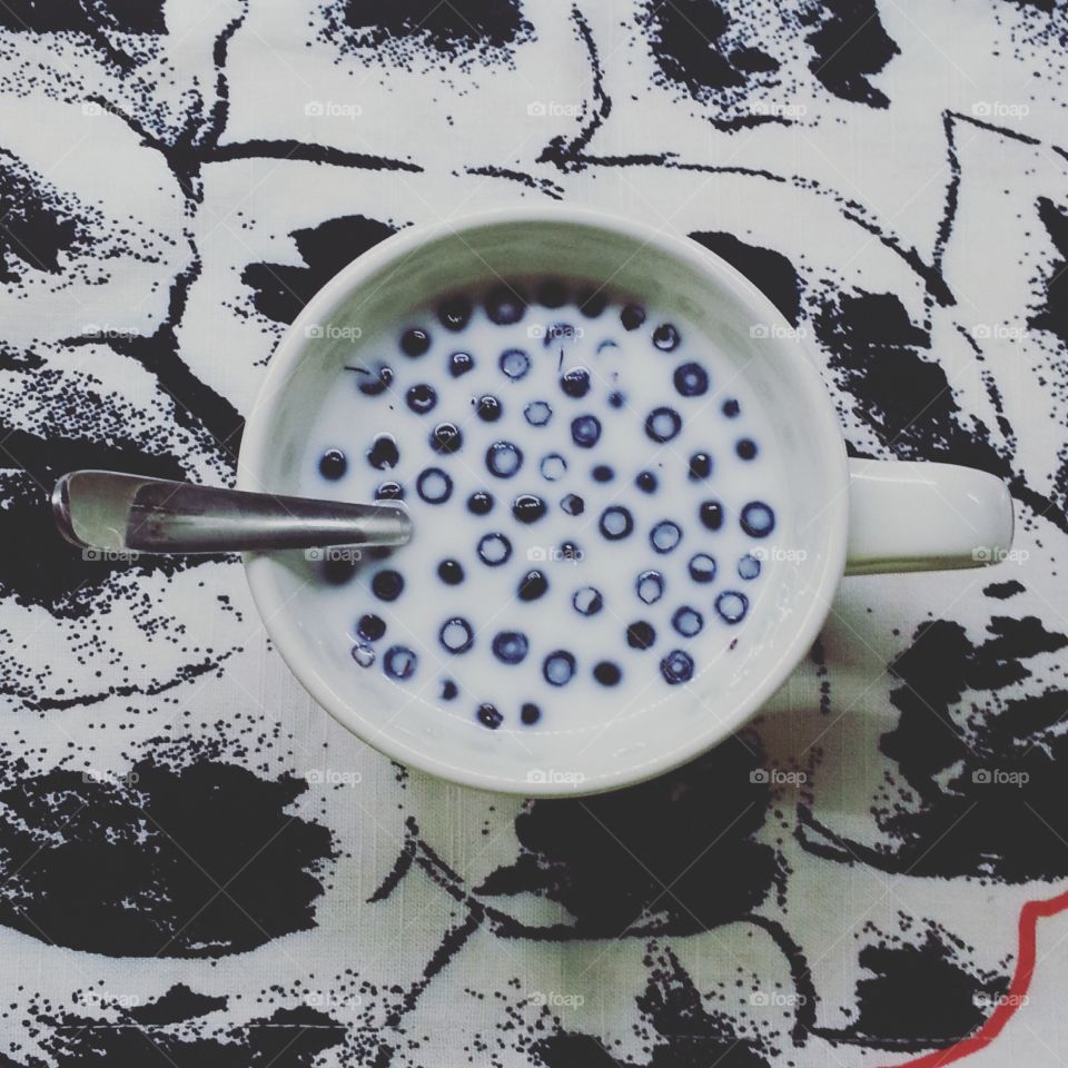 milk with berries. cup of milk with BlackBerry on the background white and black