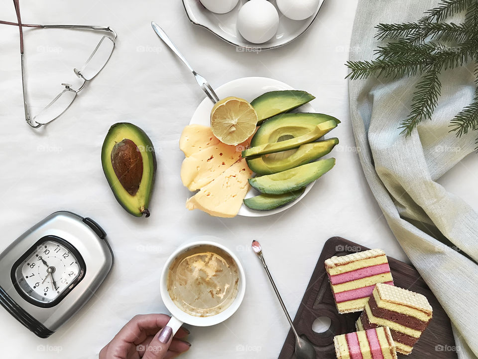 Overheard view of a healthy breakfast - boiled eggs, avocado, cheese, coffee and cookies 