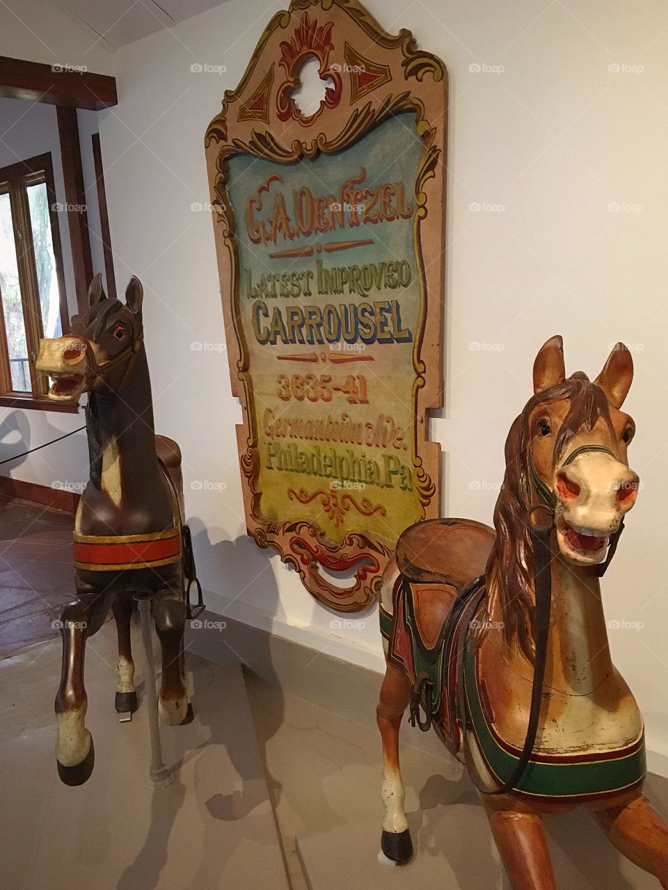 Antique wooden carousel horses in front of an antique circus sign.  History is cool! 