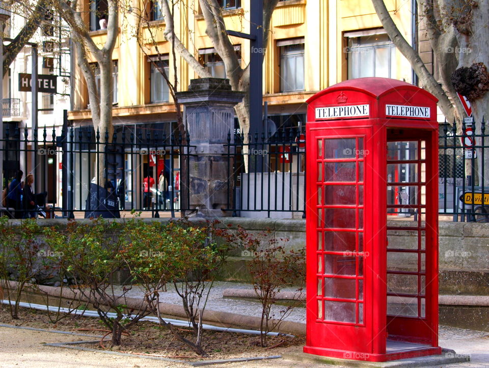 Red telephone box in a park.