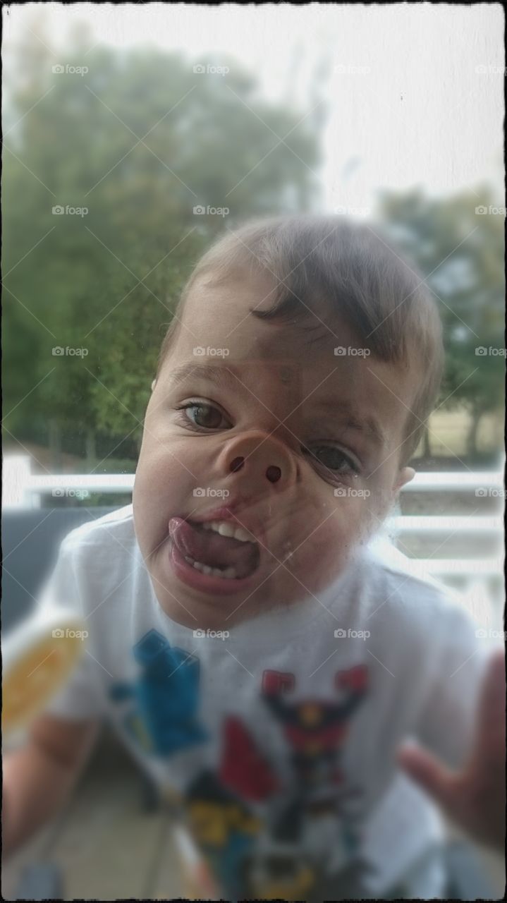 View of boy's pressed nose against window