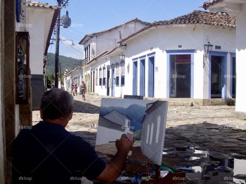 Artist painting a street, Brazil