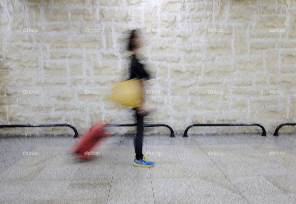 blurry woman in airport with trolley