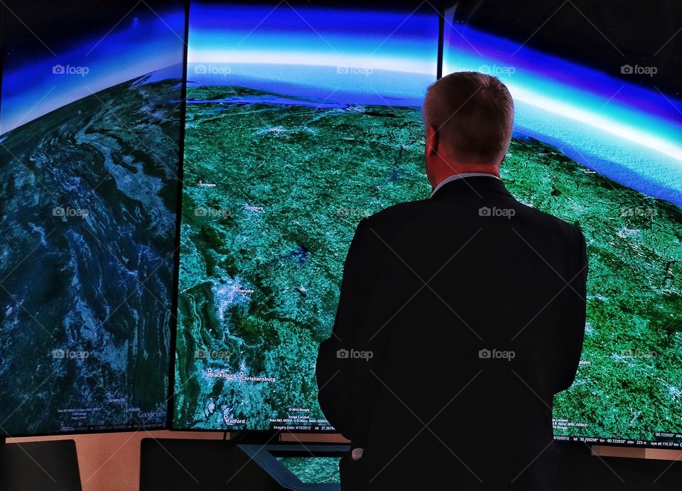 Office Worker Standing Before A Giant Display Screen