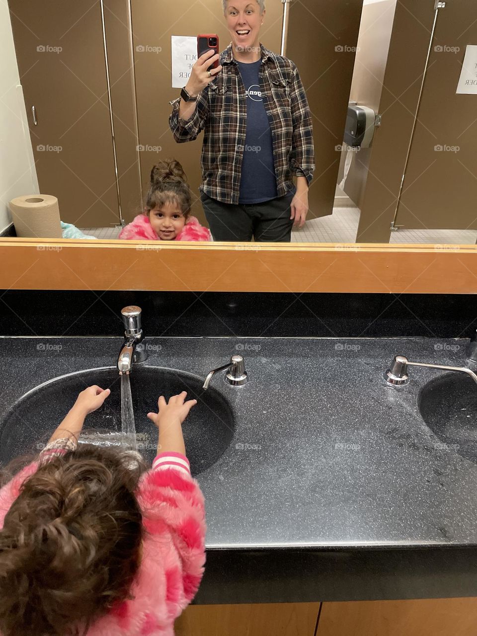 Little girl washes hands in restroom, public bathrooms with toddlers, fun with toddlers