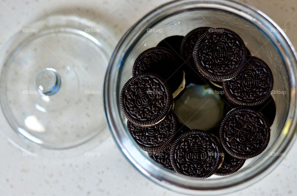 Tasty chocolate cookies on a glass jar on a counter 