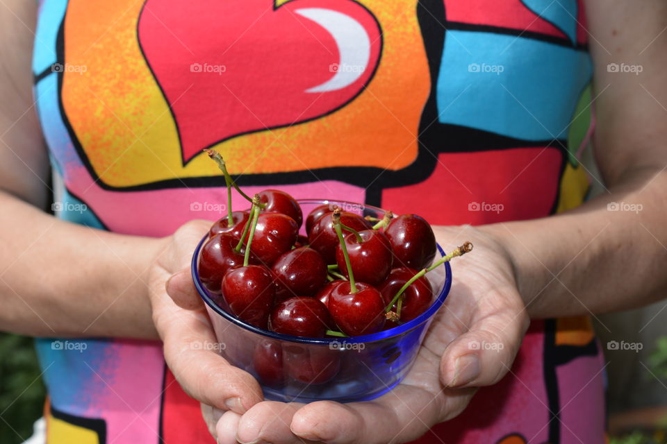 red cherry tasty summer food in the female hands