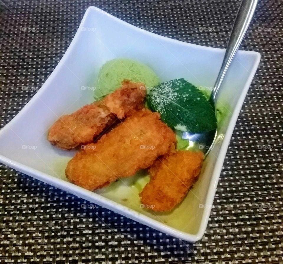 3 fried bananas with green tea ice cream and a mint leaf