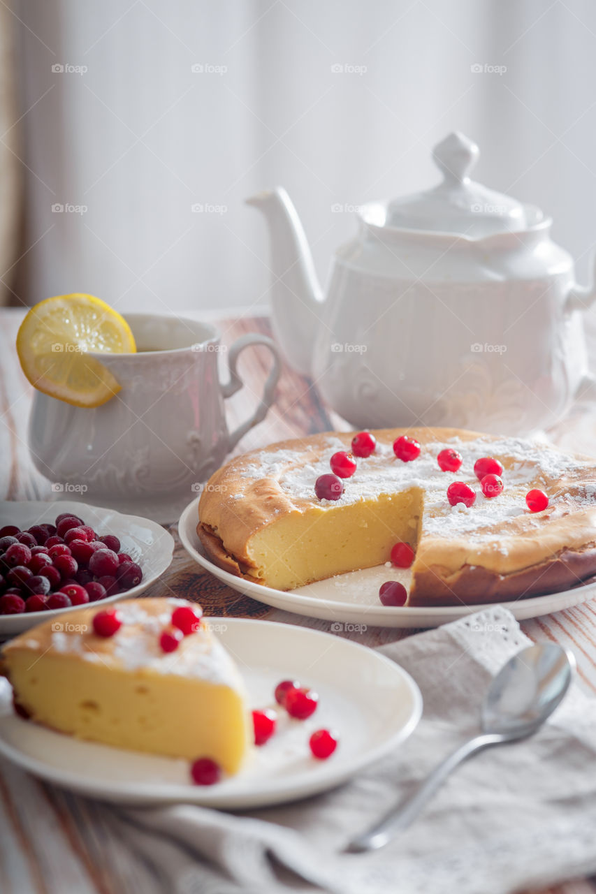 Cheesecake with cranberries and sugar on wooden background