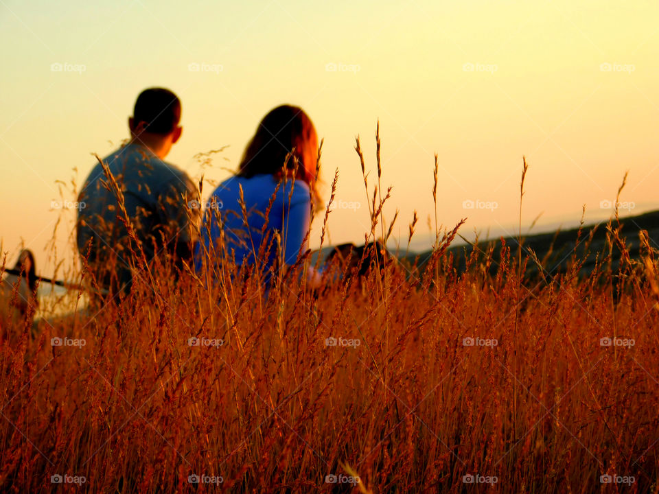 A couple awaits the sunset with anticipation 