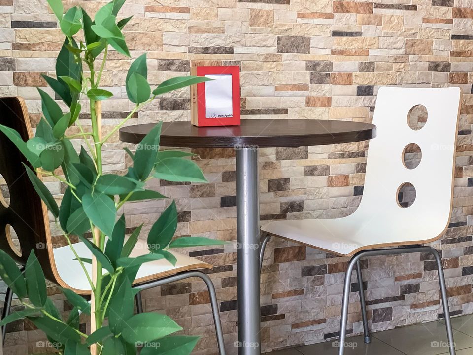 A table for 2 with a plant in a cafe