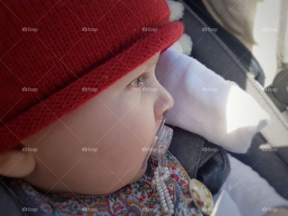 Sleepy baby girl in pushchair