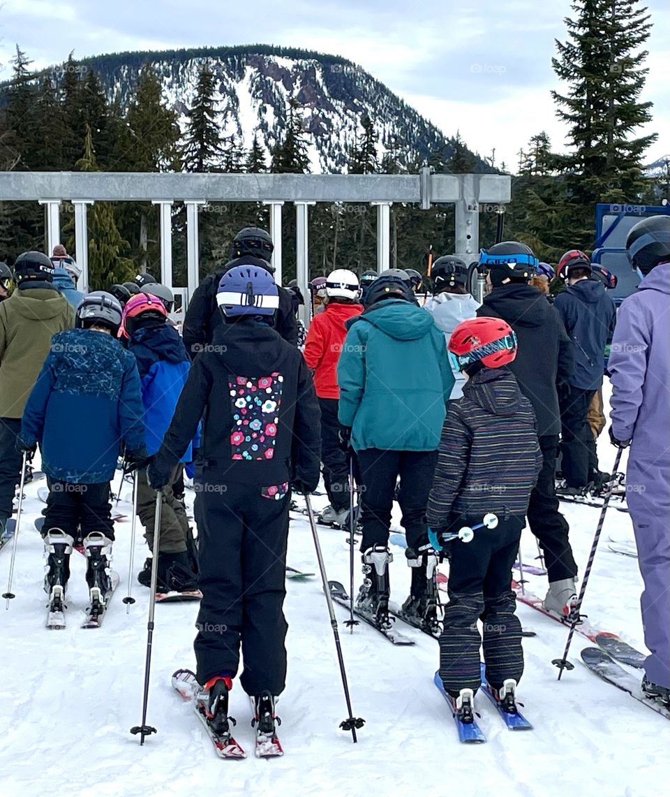 A group of skiers wait in line at the ski lift at White Pass Ski Resort for a fun day of winter activity 