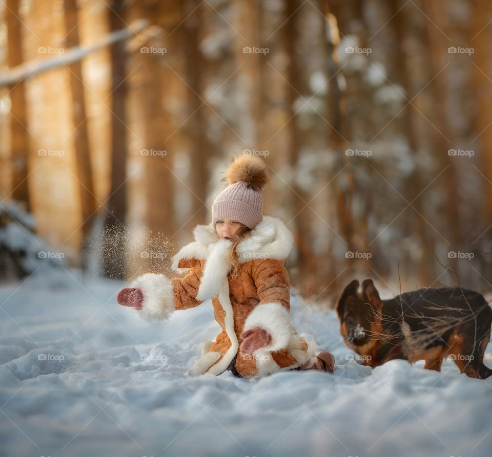 Little girl portrait with German shepherd puppy at winter