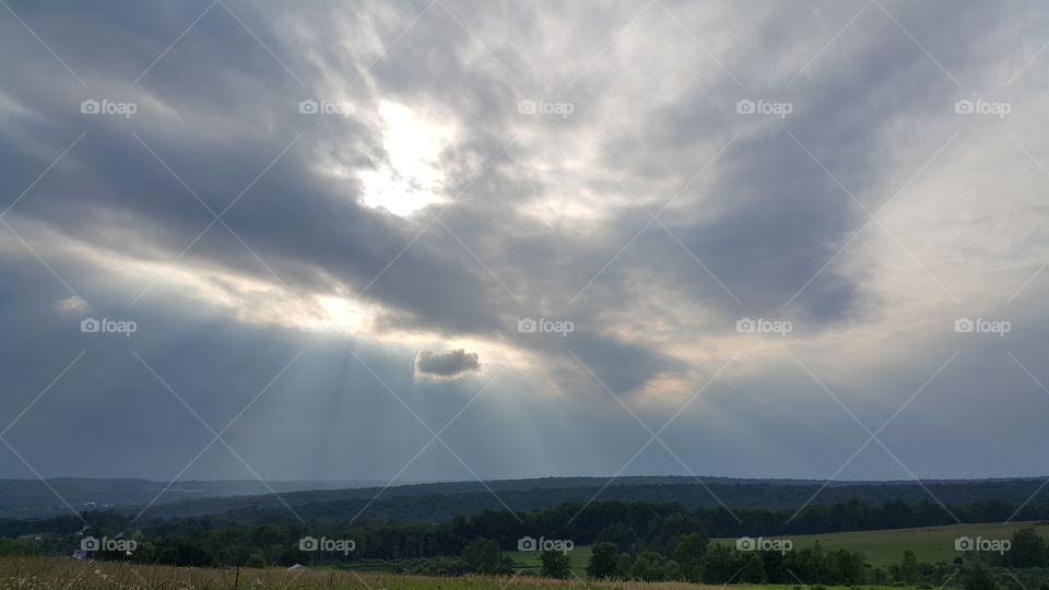 Rays of sunlight shining from behind a cloud.