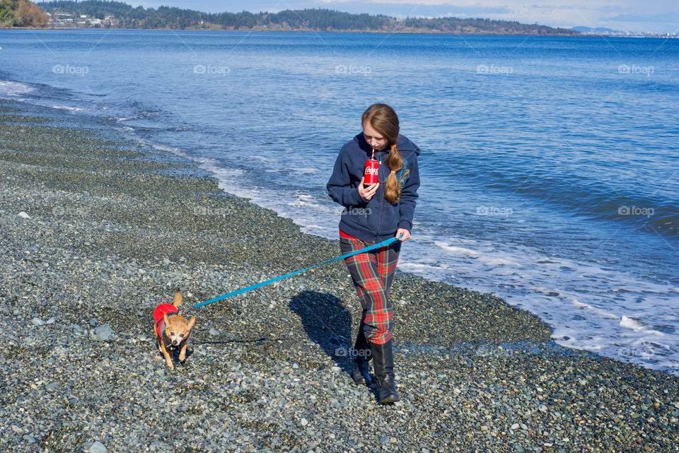 Girl walking dog while sipping on cola