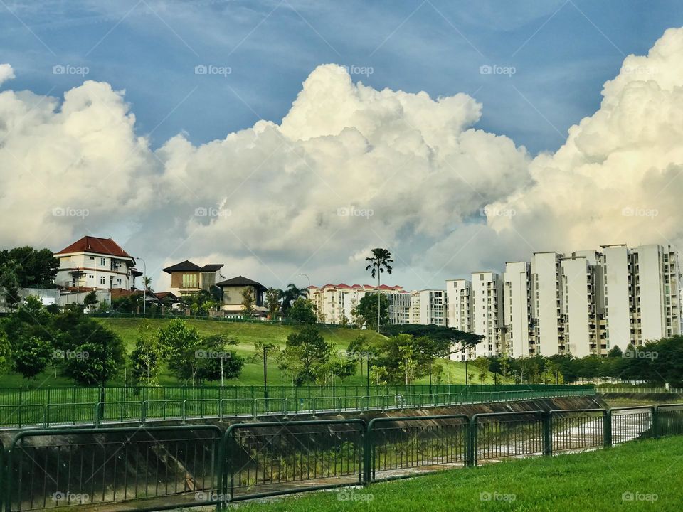 A beautiful big bunch of silver clouds are passing very near to the houses in the city 