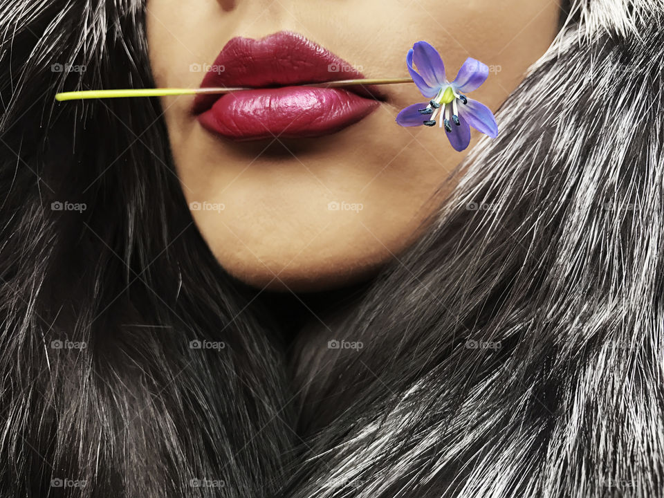 Red lips holding a snowdrop