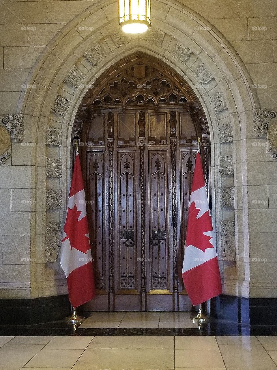 Beautiful old heritage wooden door and two Canadian flags.