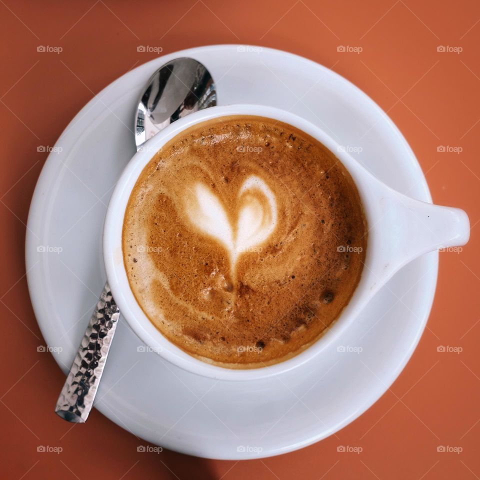 Coffee cup on the table with coffee and a latte art heart