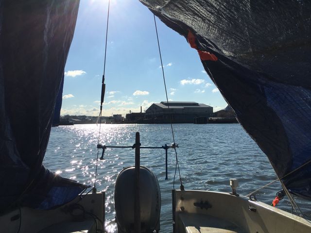From inside the Salvation, our sailboat in Newtown Creek, Long Island City, Queens, New York you can see the waters of the East River and the shore on the other side. The sunlight is reflecting on the waves. Photo from 2018. Hypnotic Productions