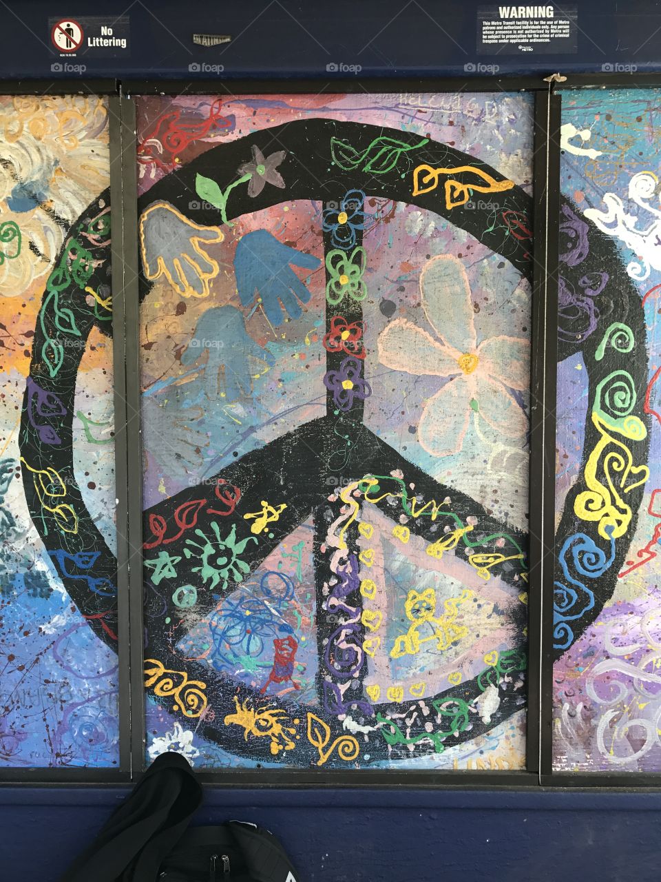 Peace sign and some abstract art at a bus stop