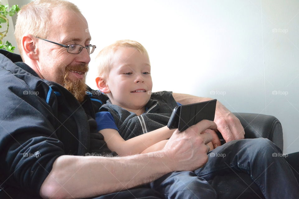 Father and son playing on the phone