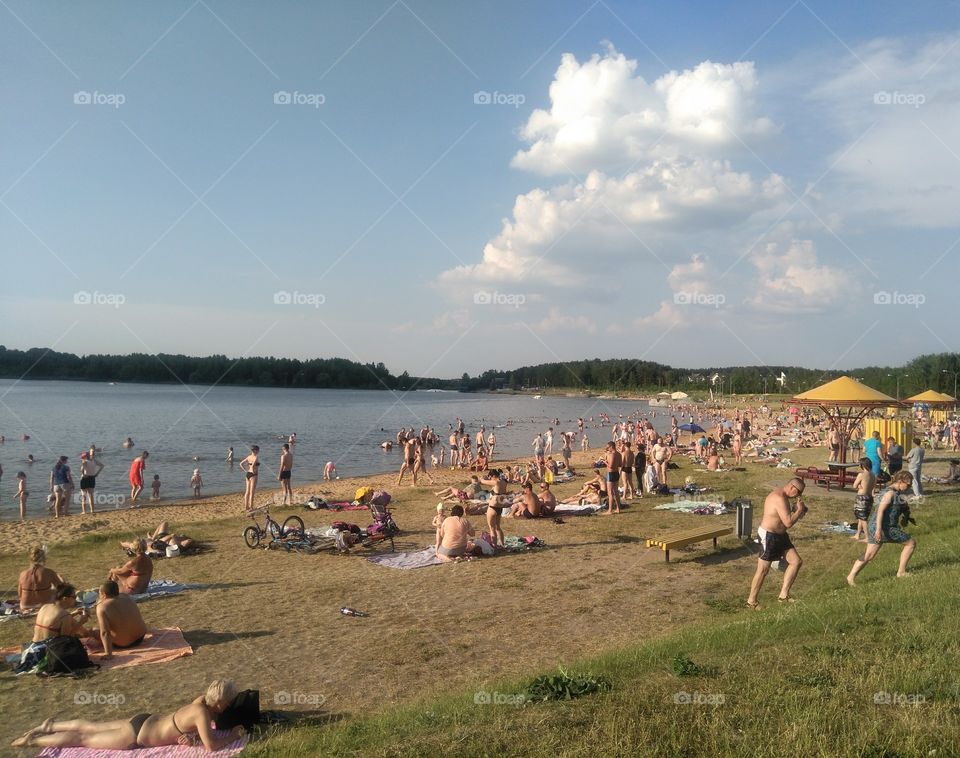 people resting on a lake shore summer heat