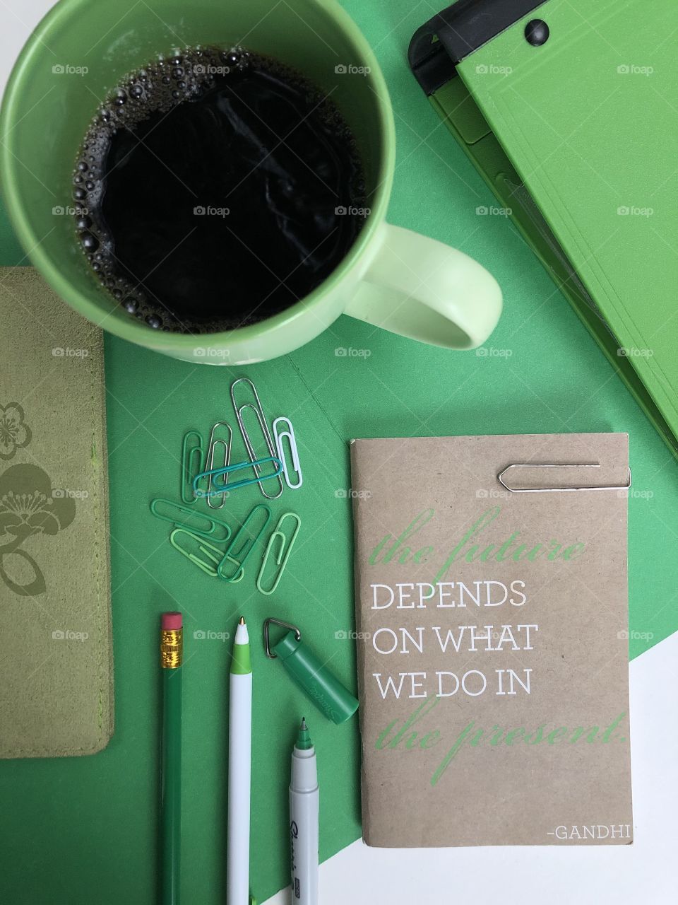 A green and lime themes flat lay with a motivational sayings on a notebook