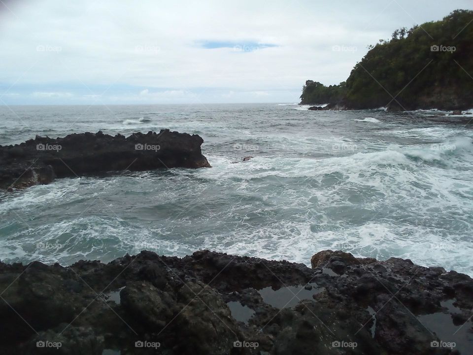 Lava Rock protrusions in a mildly turbulent water.