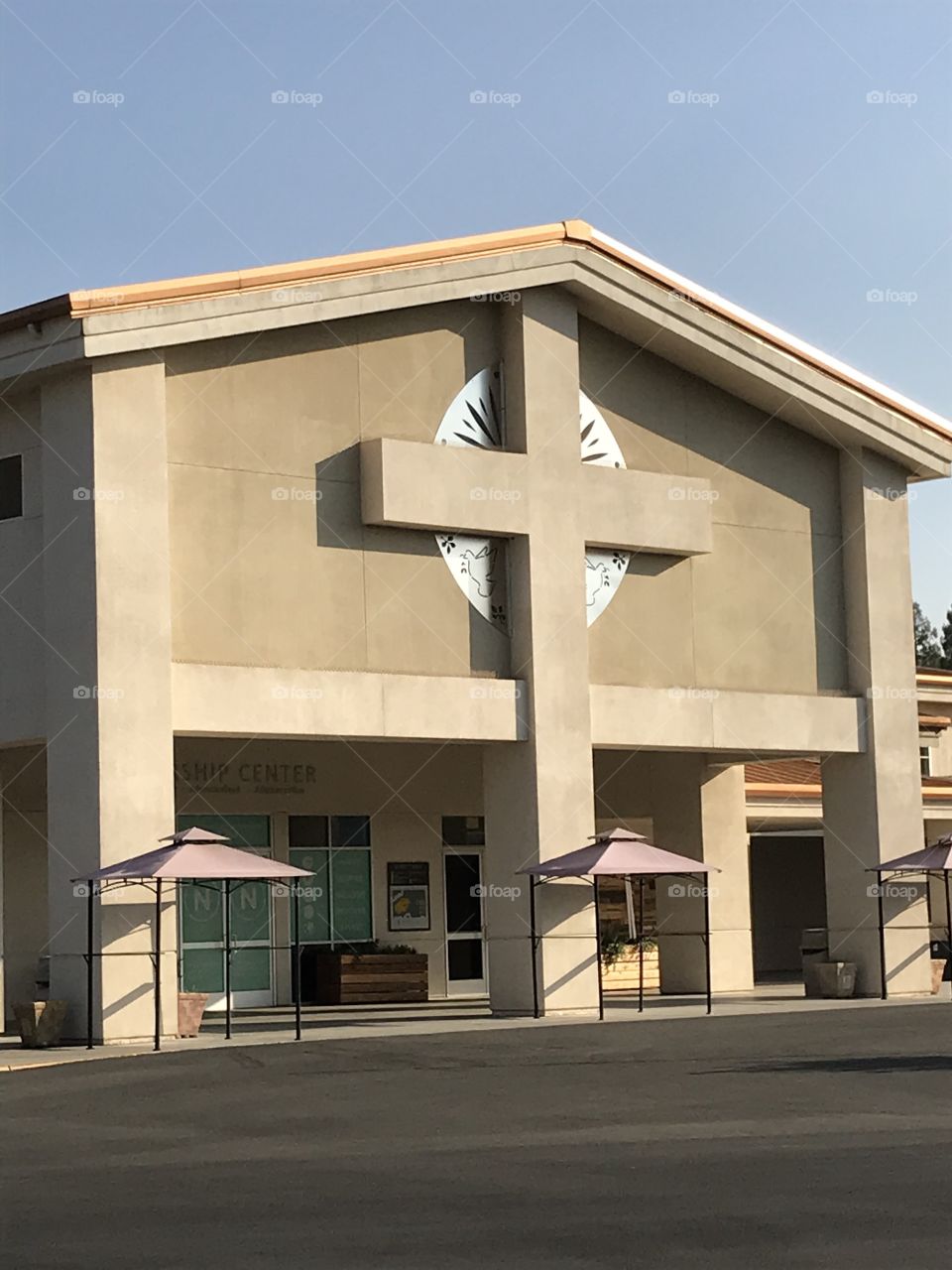 Building of the main sanctuary of a church. A very ample cross adorns the facade of the building. It perfectly fits right in.