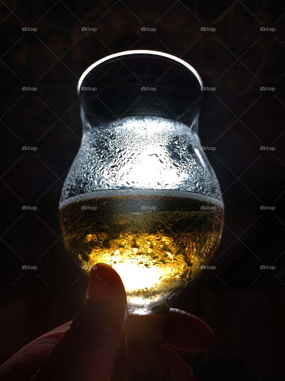 Glass of beer at night against the light