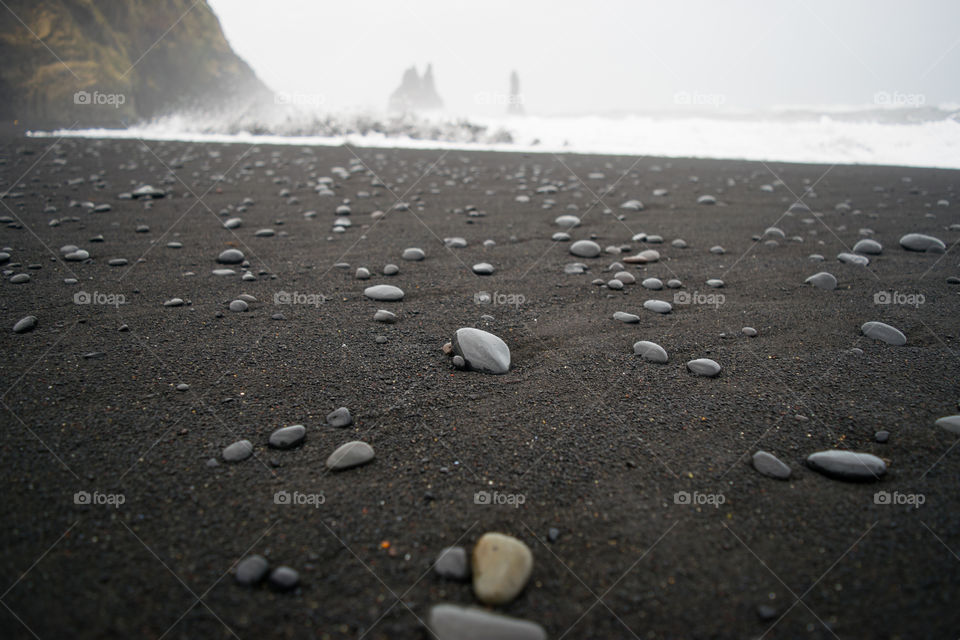 Rocks among the black sand of an Icelandic beach