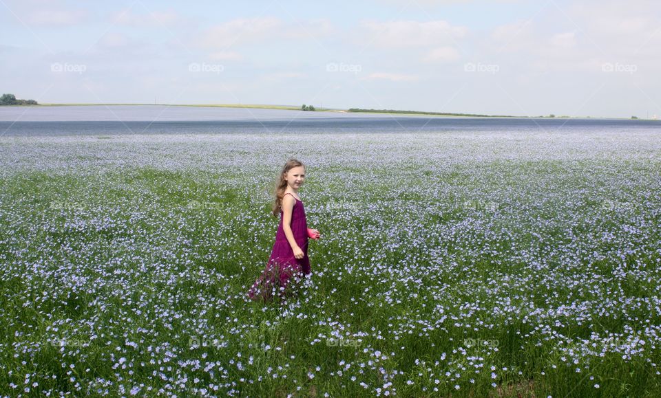 Girl in a field of purple/blue flax.