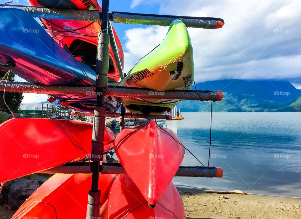 View past colourful stacked kayaks of vancouver's north shore across the inlet from Port Moody, BC, in Vancouver's Lower Mainland area.