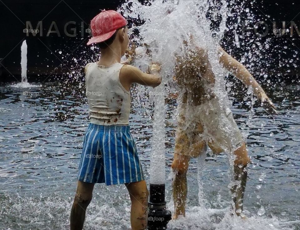 Sculpture of children playing in a water fountain.