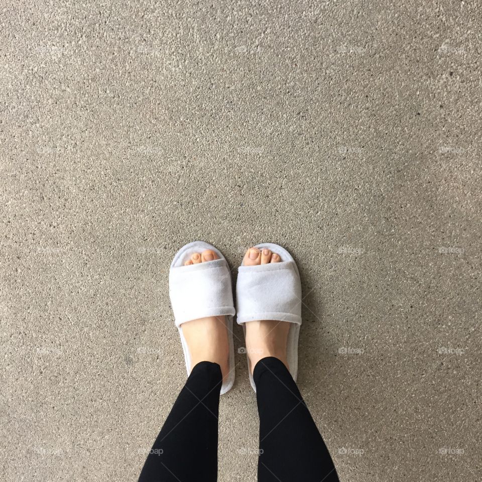 Close up of a woman's white Fluffy slippers standing great for any use.