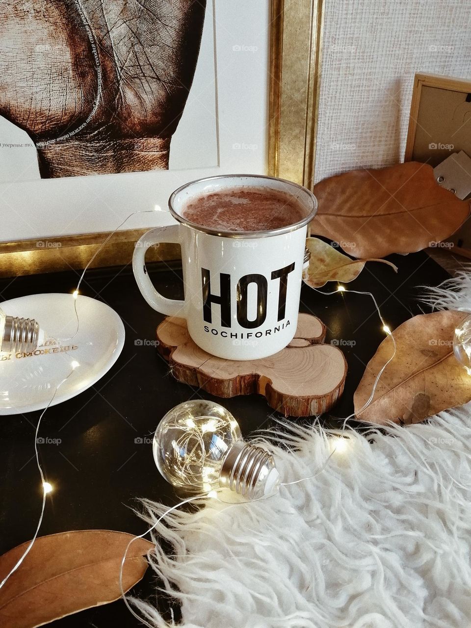 Warm drink in a mug, white mug with hot drink, autumn, fall leaves, winter, cozy home, bulb lights, winter garland