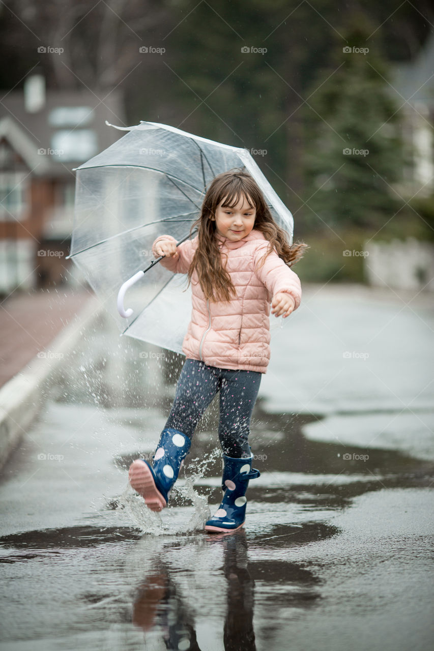 Little girl have fun under the rain.