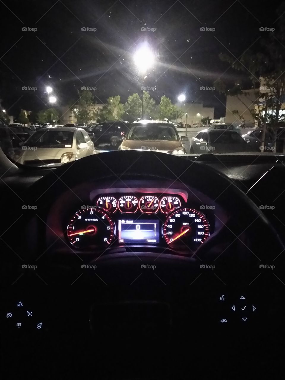 Dashboard, looking out into a full parking lot.