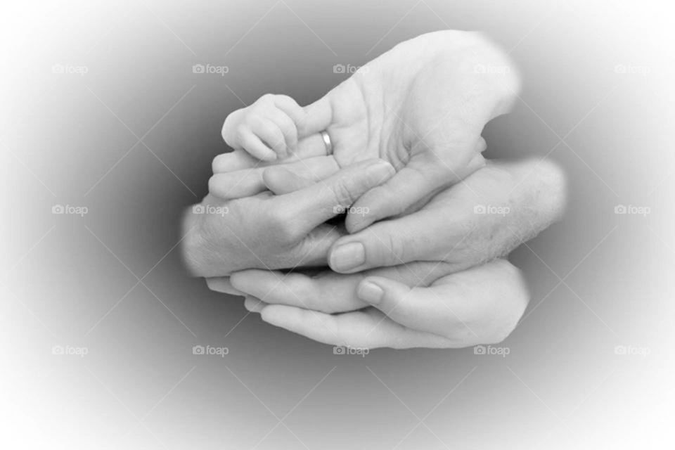 Three generations of hands. Newborn,  parents, and grandparents hands