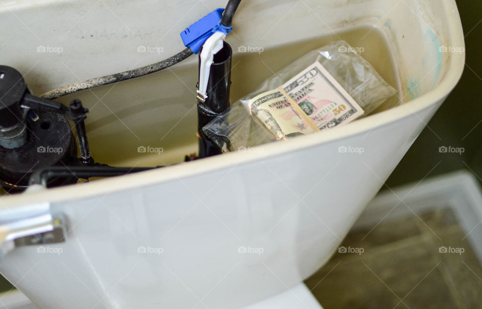 Money in a plastic bag that is hidden in a toilet tank